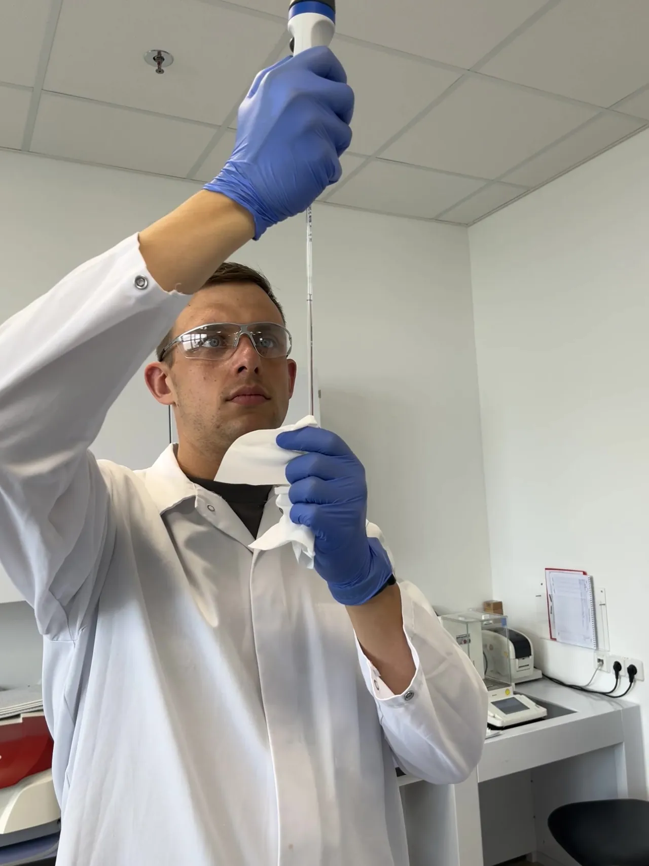 Peter Maibaum im Laborkittel prüft eine Kolbenhubpipette