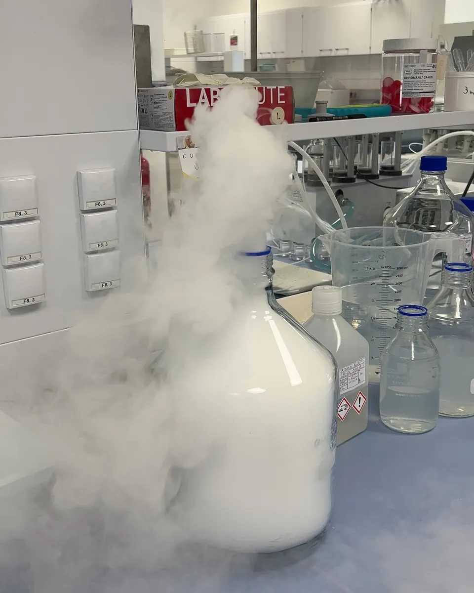 Trockeneisnebel quillt aus einer Laborflasche auf dem Labortisch